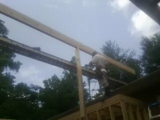 Carpenter setting a ridge beam over a new addition frame — Ice Dam Removal by Roofing Brothers in Tremont City