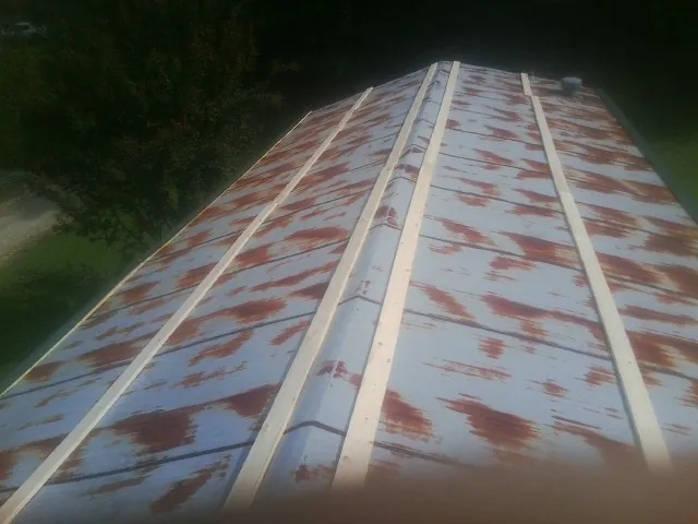 Rusted metal roof panels with new wood purlins before replacement — Storm Damage Roof Repair in Tremont City by Roofing Brothers