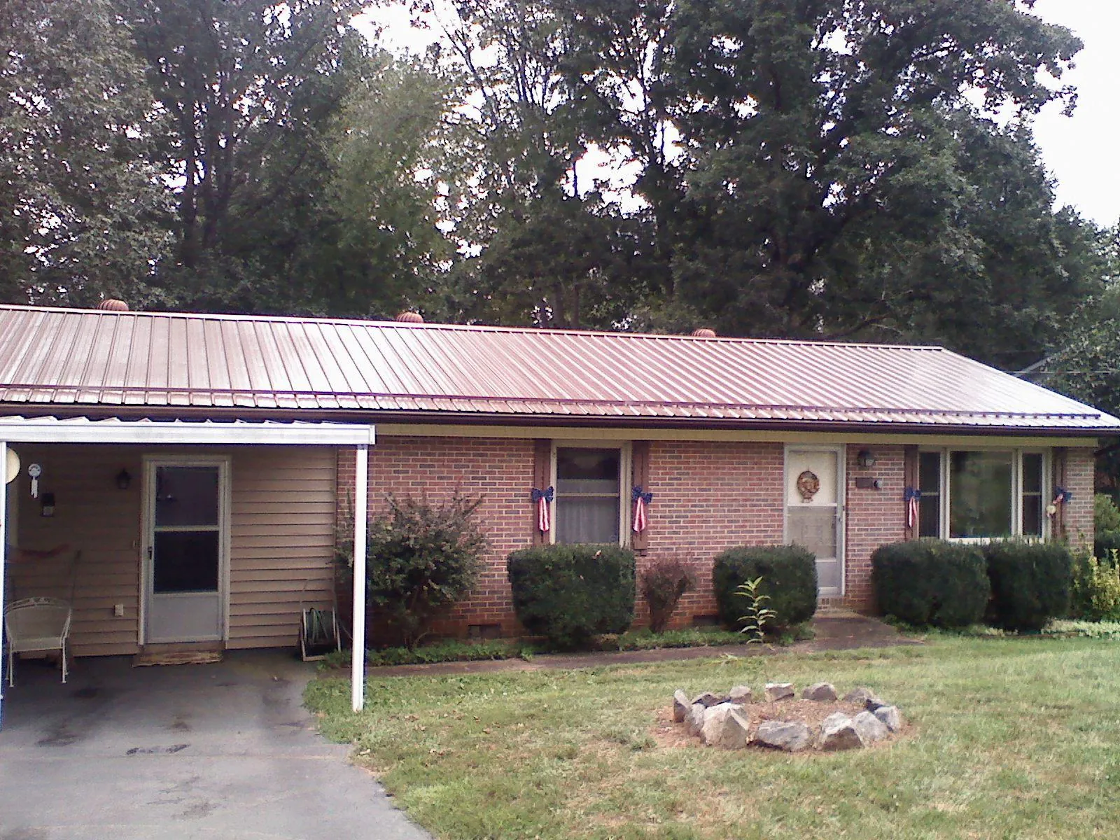 Bronze metal roof and carport on a brick ranch home — Roof Repair work by our crew in Tremont City
