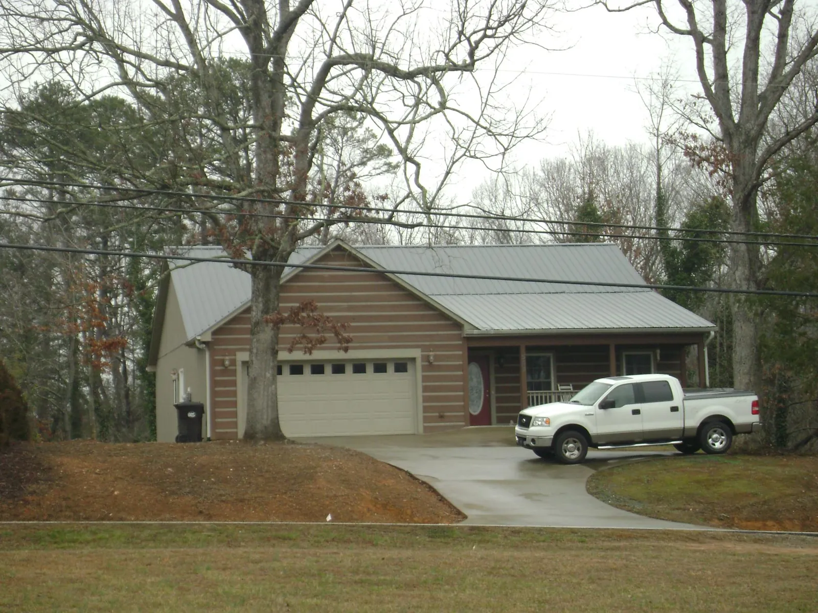 Gray metal roof on a log sided house with an attached two car garage in Tremont City